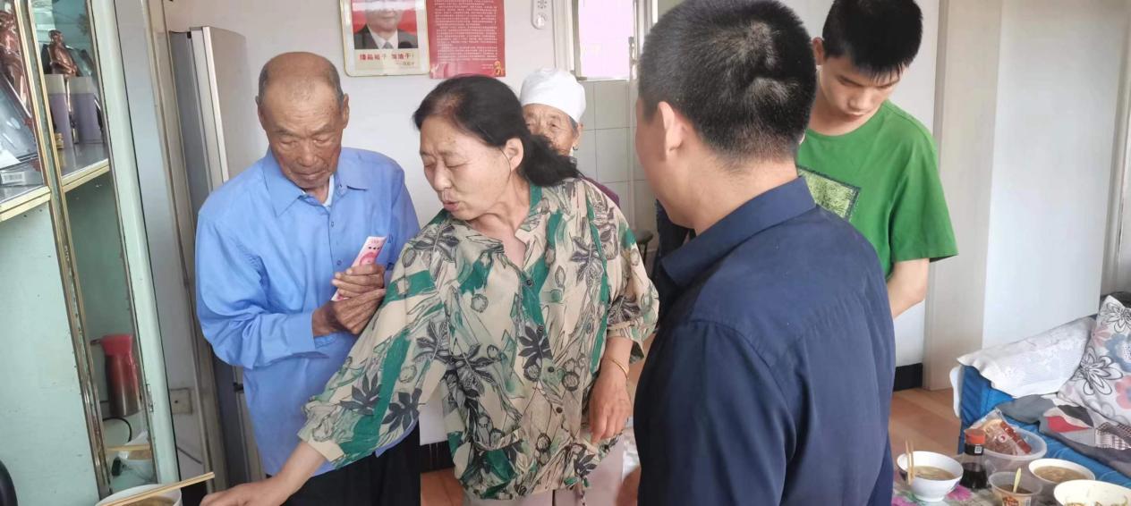 秦金顺同志与老党员家属交谈.jpg
