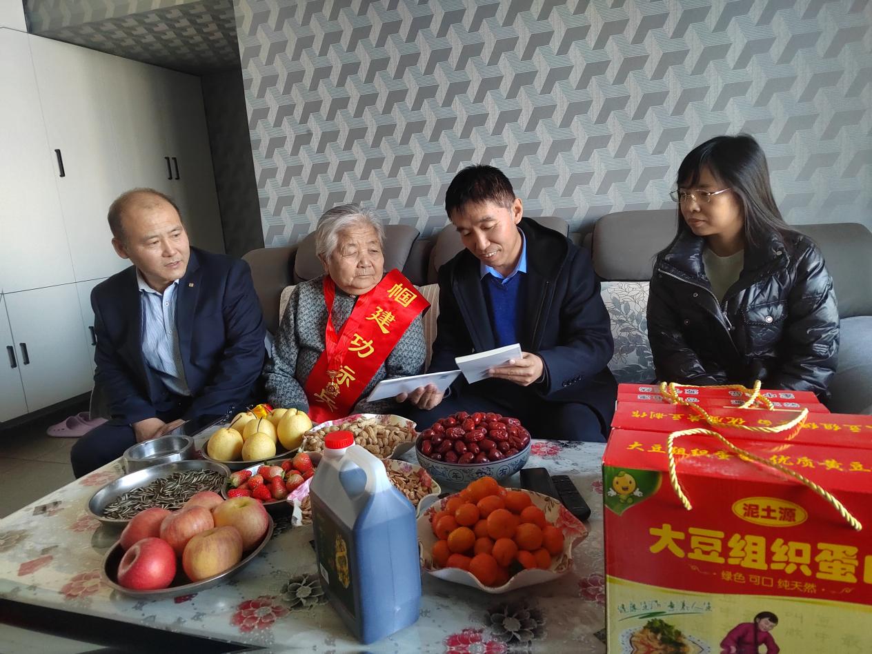 工作人员为82岁科级退休干部郭志萍送上二十大学习资料.jpg
